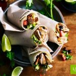 Chicken burrito served with lime wedges